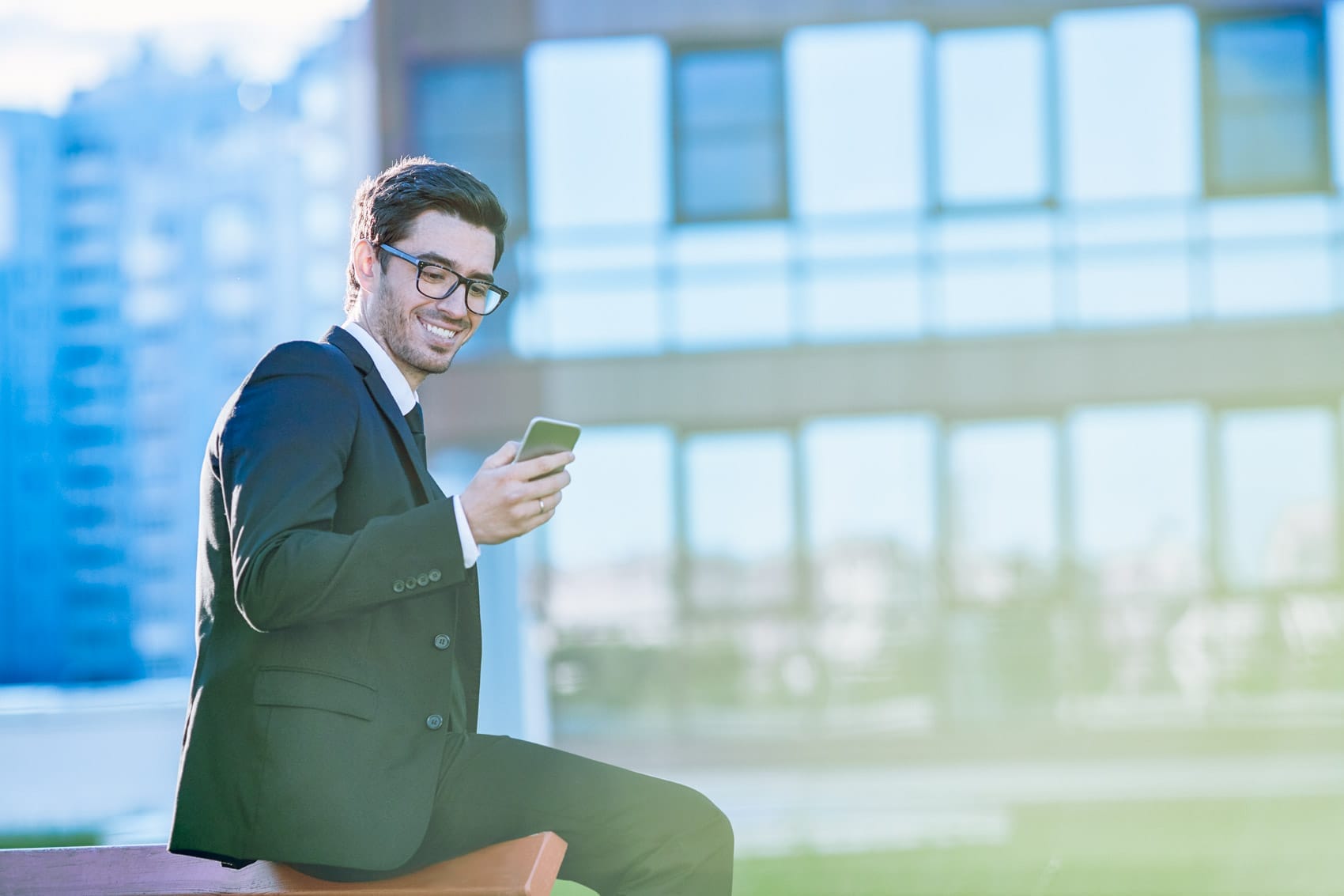 Makler, der im Freien eine SMS auf seinem Smartphone schreibt